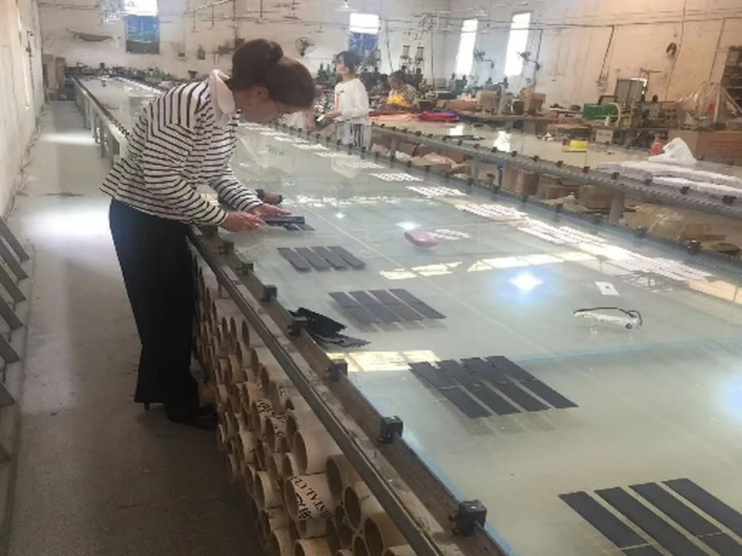 Bole factory workshop with illuminated inspection and alignment tables in Longchuan, Guangdong